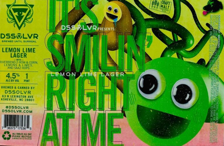 “It’s Smilin’ Right At Me” beer label from DSSOLVR: A green cartoon face with large eyes and a wide smile dominates the right side. A brown worm-like creature drips blue liquid near top center. Green tentacle shapes swirl around them against yellow-green background.