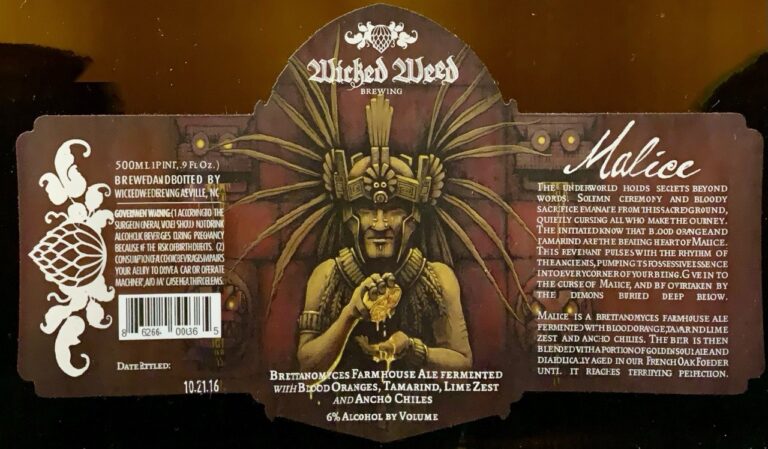 Malice (2016) beer label from Wicked Weed: A figure in an ornate headdress holds a glowing object against a dark background with radiating lines and decorative borders.