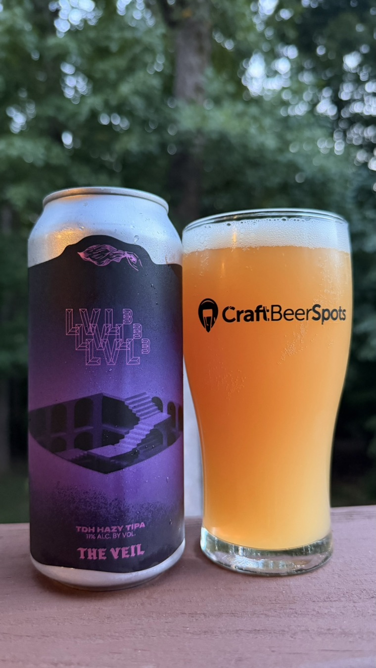 CraftBeerSpots photo of The Veil LVL cubed can beside a glass of hazy beer